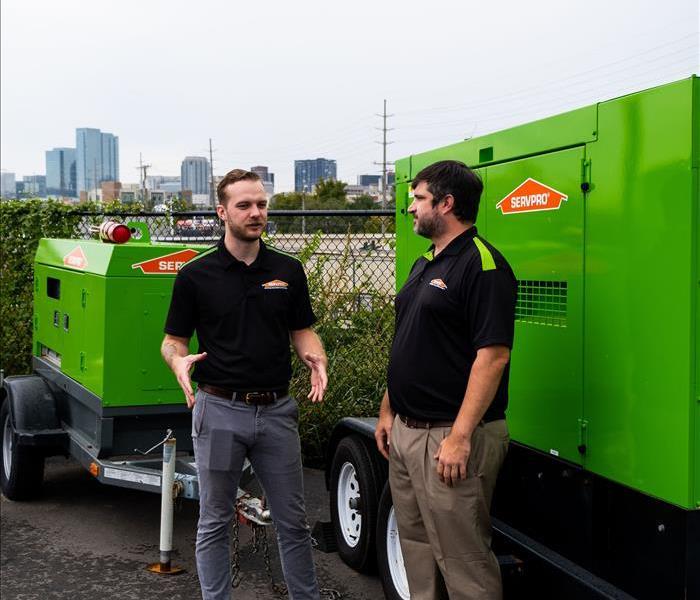 Two men standing next to SERVPRO vehicle