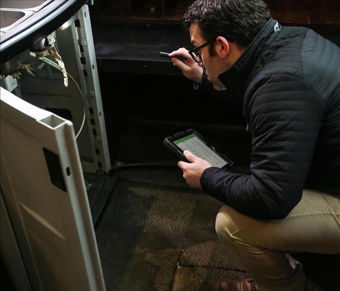 Technician looking at water damage 