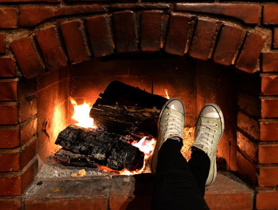 person sitting at fireplace with shoes 